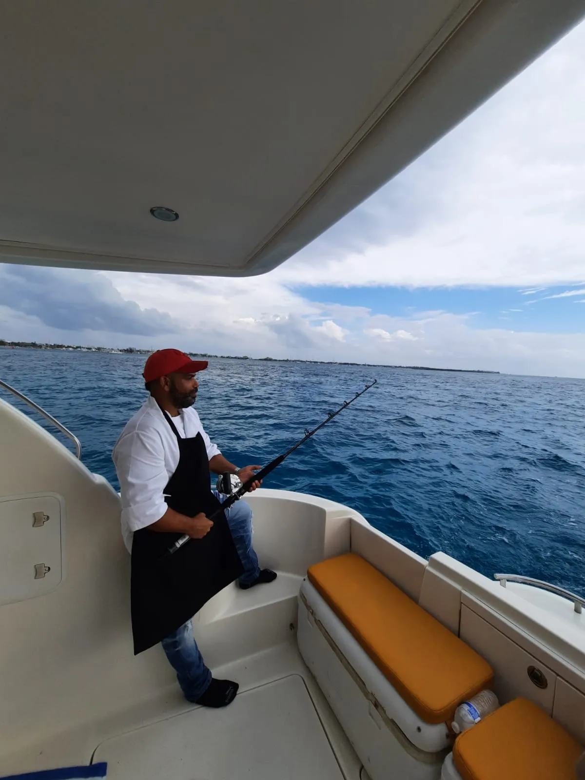 Chef Orel reeling in the day's fresh catch aboard a boat off the Riviera Maya coast