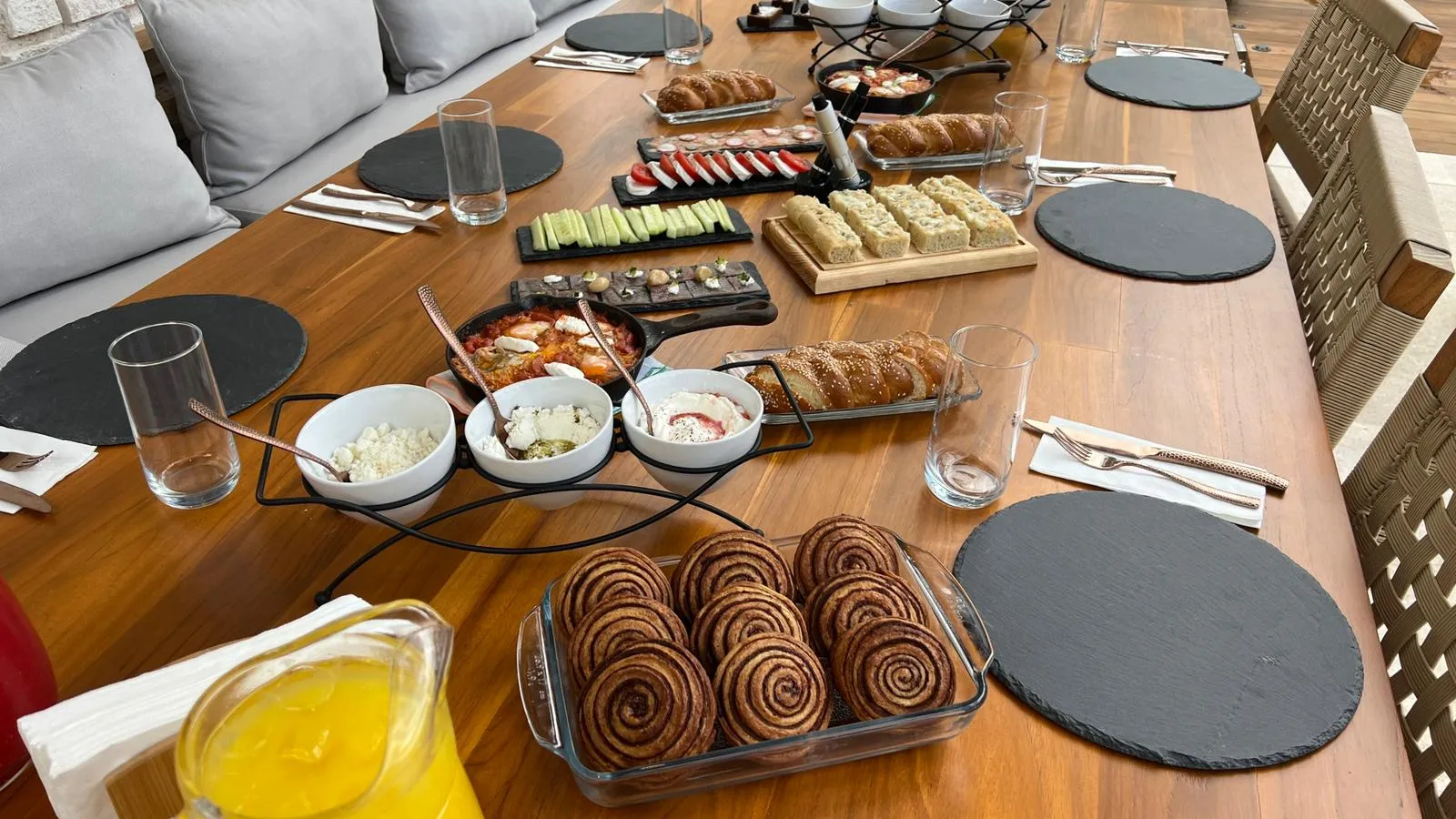 An elegant kosher brunch spread of shakshuka, fresh breads, dips and pastries on slate boards at a Riviera Maya villa