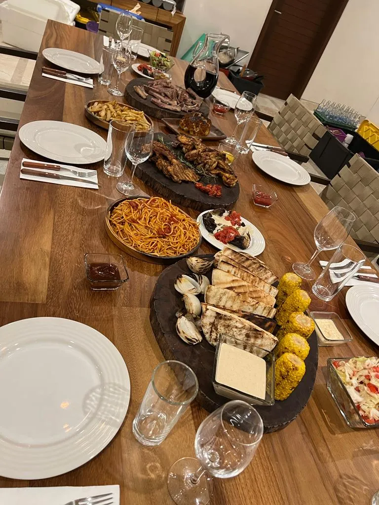 An elegant kosher feast of grilled meats, sides and salads laid across a long wooden table