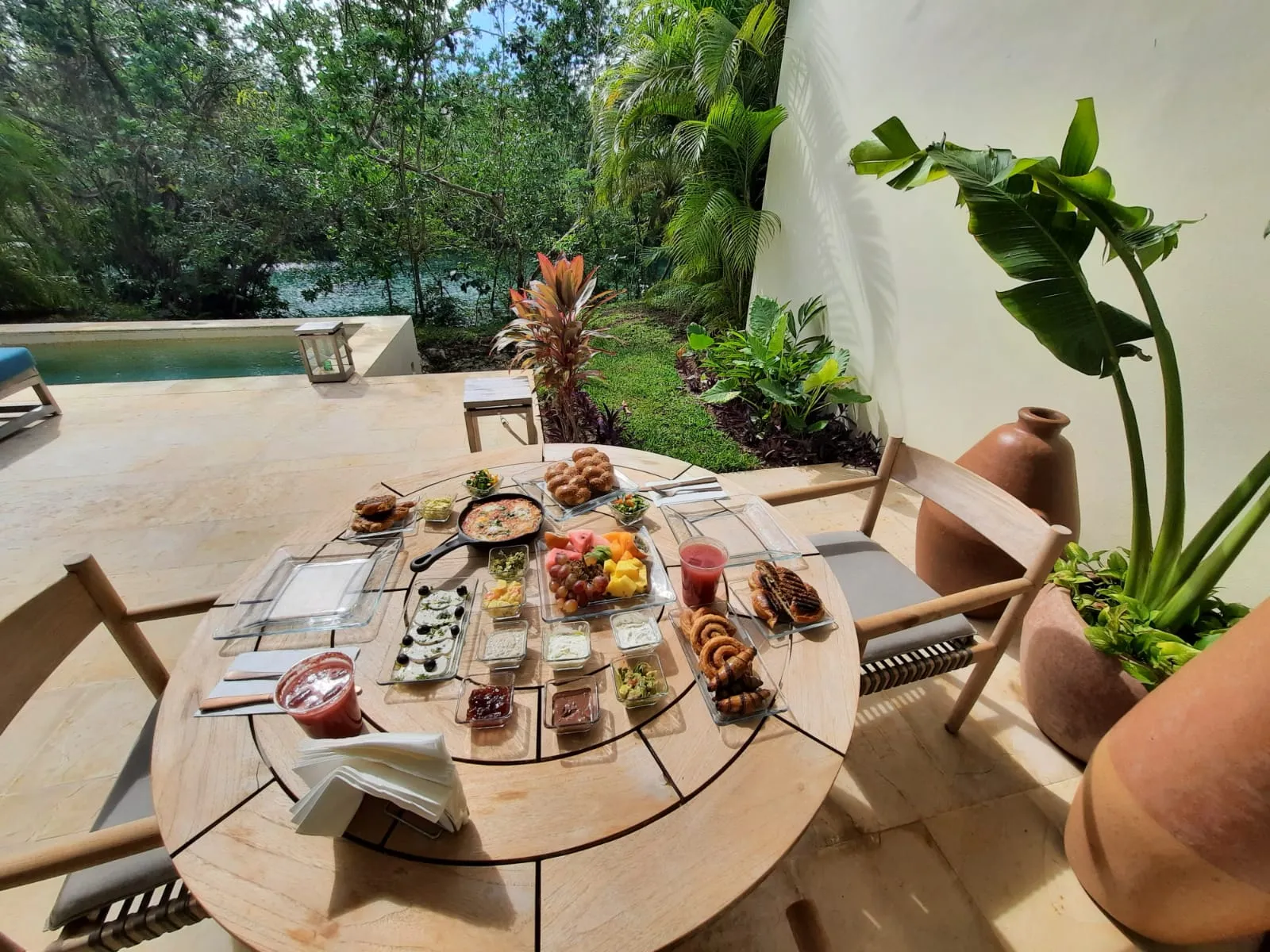 A kosher brunch laid out on a round table on a tropical villa garden patio in the Riviera Maya